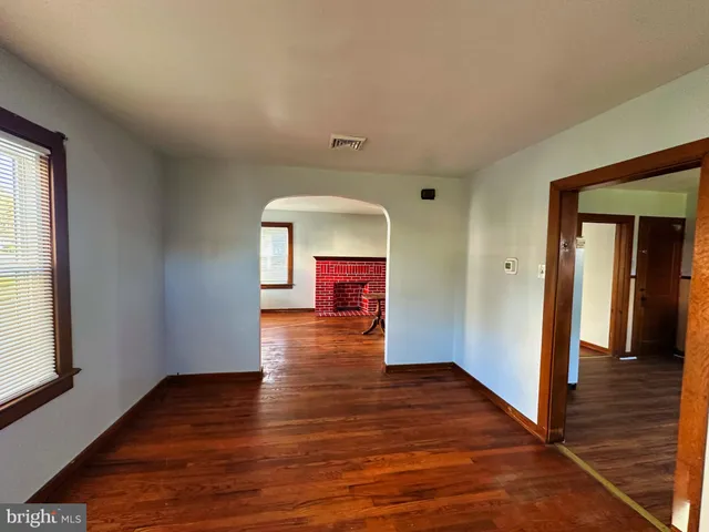 a view of a hallway with wooden floor and closet