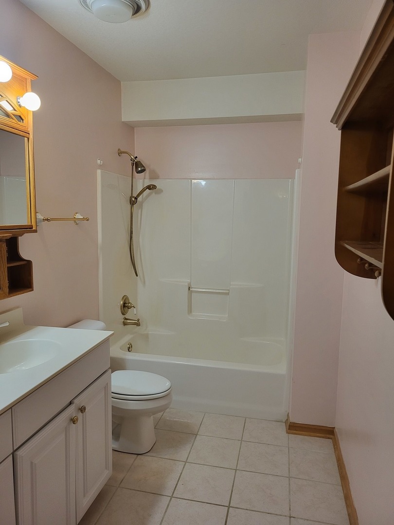 10120 East Hickory Ridge Drive Rochelle, IL 61068 - Photo 33 of 39 a bathroom with a granite countertop sink a toilet and shower
