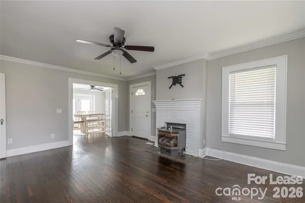 a view of empty room with wooden floor and fireplace