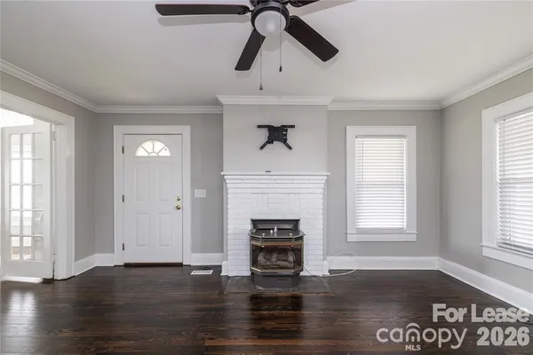 a view of an empty room with window and wooden floor