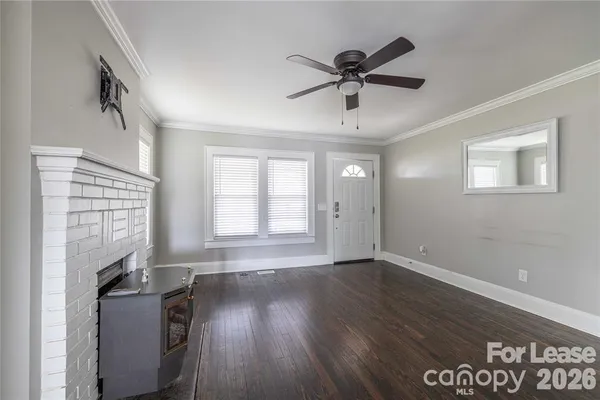 a view of an empty room with a window and wooden floor