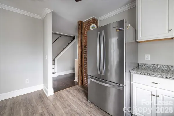 a kitchen with a refrigerator a sink and wooden floor