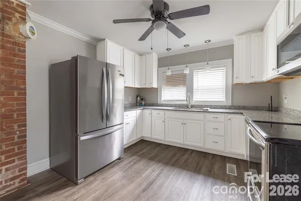 a kitchen with granite countertop appliances cabinets a sink and a window