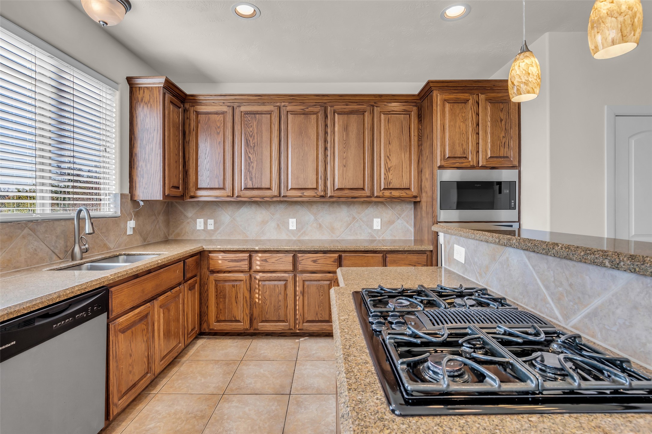 1803 Stacy Crest Houston, TX 77008 - Photo 7 of 28 The kitchen is equipped with stainless steel appliances, including a microwave, dishwasher, garbage disposal, gas cooktop, and single oven.