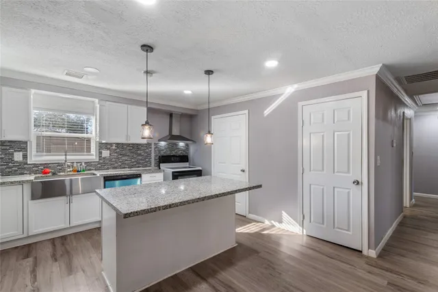 a kitchen with stainless steel appliances granite countertop a sink stove and wooden floor