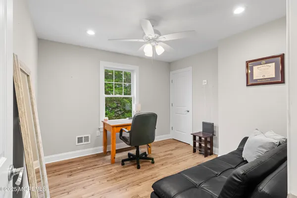 a living room with stainless steel appliances furniture a dining table wooden floor and kitchen view