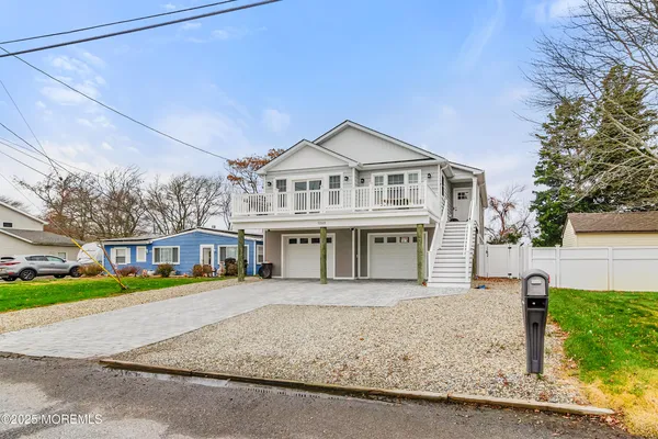 a front view of a house with a yard and potted plants