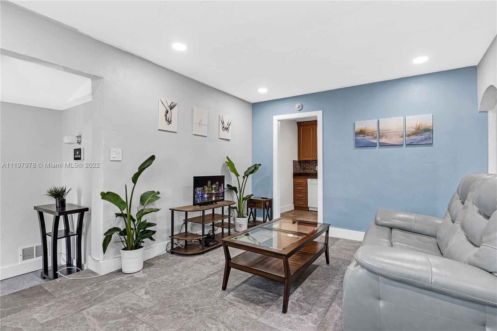 a living room with furniture potted plant and wooden floor