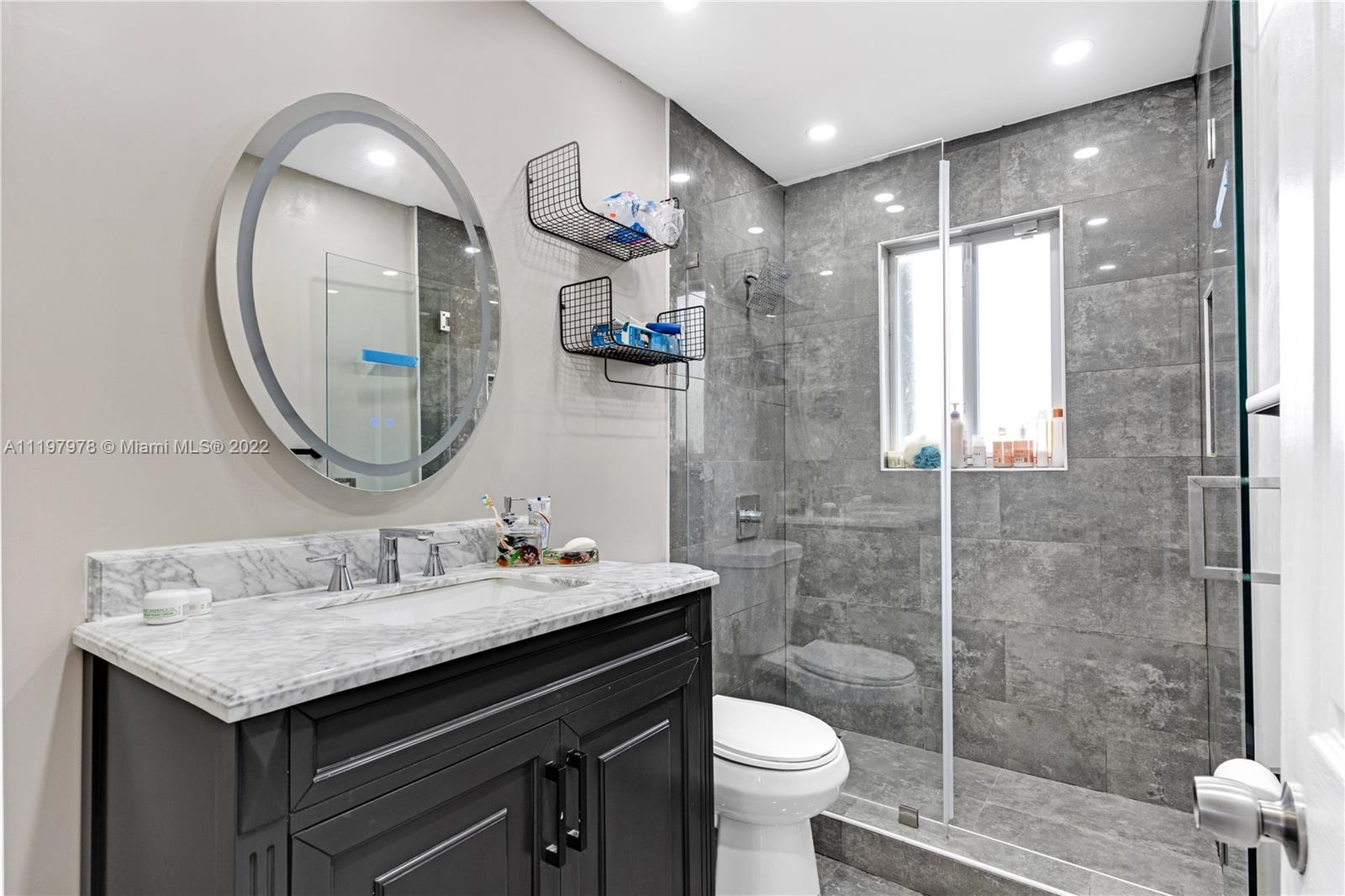 2123 Funston Street Hollywood, FL 33020 - Photo 11 of 30 a bathroom with a sink a toilet and a mirror