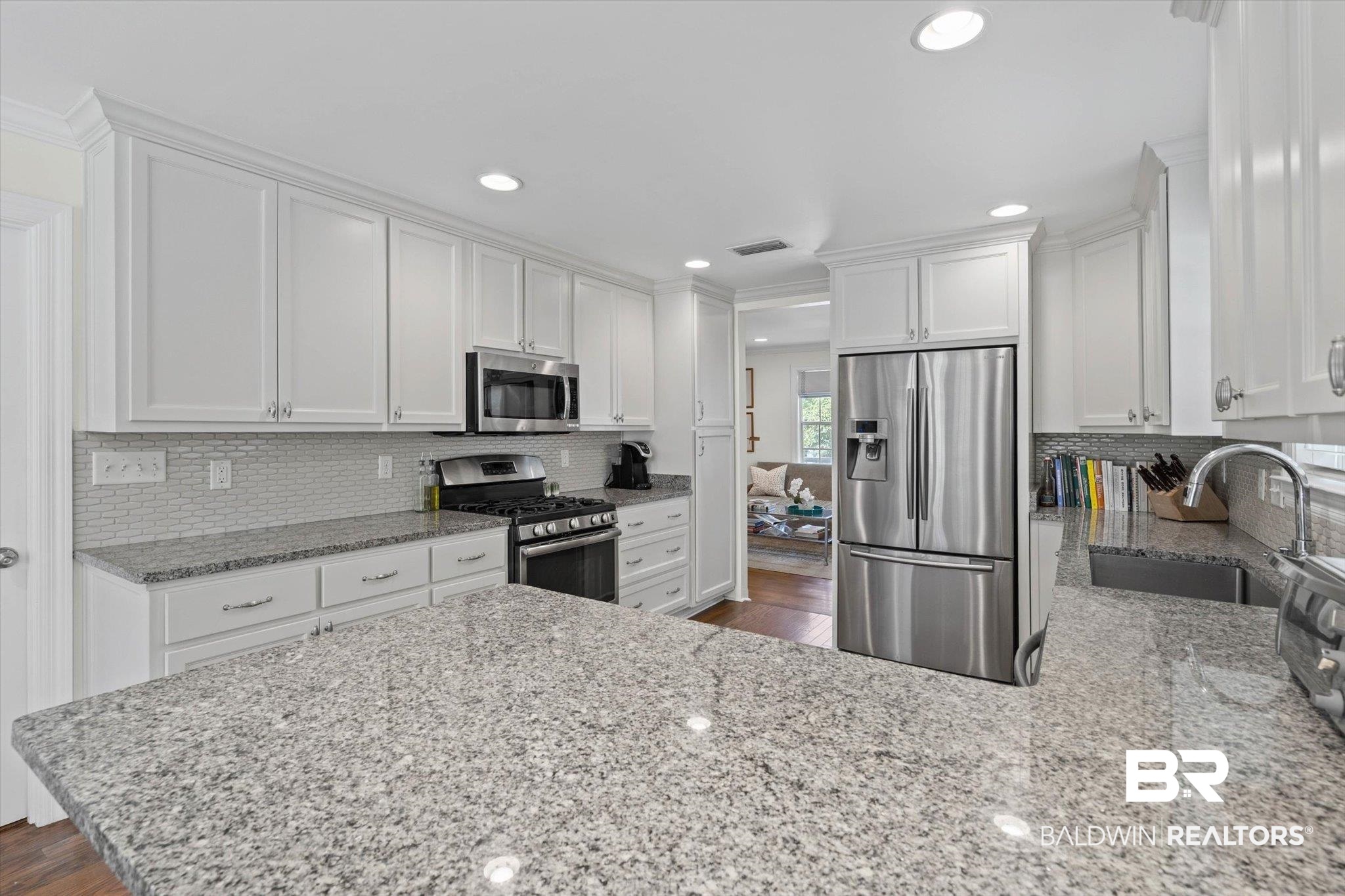 77 North Hathaway Road Mobile, AL 36608 - Photo 11 of 33 Kitchen featuring backsplash, stainless steel appliances, light stone countertops, white cabinetry, and recessed lighting