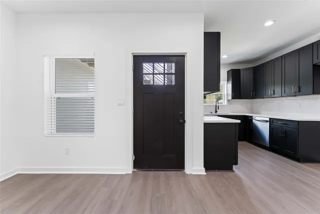 a living room with stainless steel appliances kitchen island granite countertop a stove a sink and a refrigerator