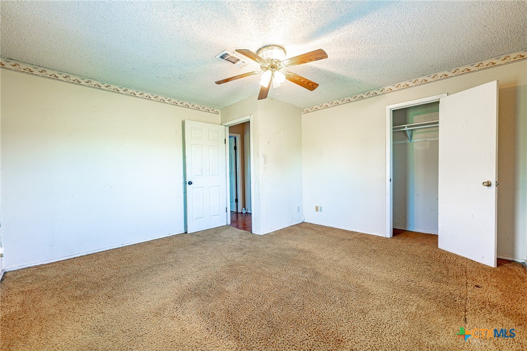 3300 State Highway 95 Shiner, TX 77984 - Photo 17 of 26 a view of a big room with wooden floor and a chandelier fan
