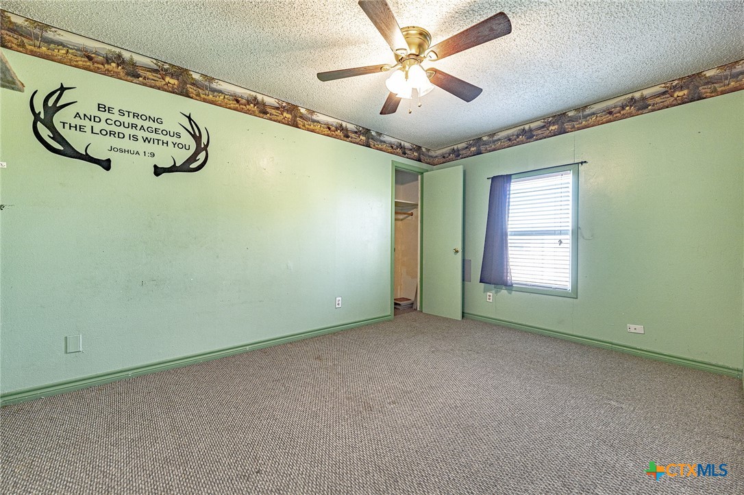 3300 State Highway 95 Shiner, TX 77984 - Photo 19 of 26 an empty room with a window and a ceiling fan