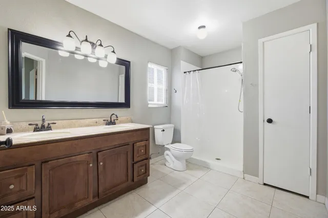 a bathroom with a double vanity sink mirror and toilet