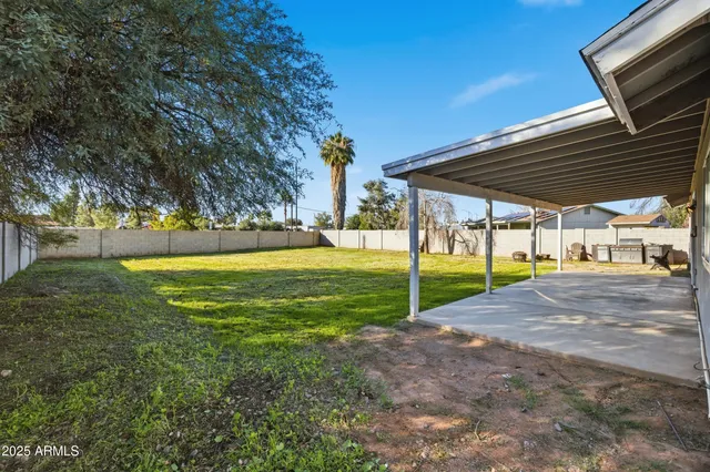a view of a house with backyard and a tree