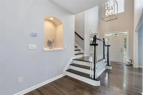 a living room with furniture a flat screen tv and kitchen view
