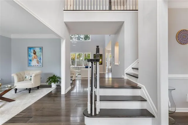 a kitchen with a sink dishwasher and white cabinets with wooden floor