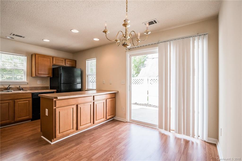 11228 Grass Field Road Charlotte, NC 28213 - Photo 11 of 26 a kitchen with stainless steel appliances granite countertop a refrigerator a sink dishwasher a stove and white countertops with wooden floor