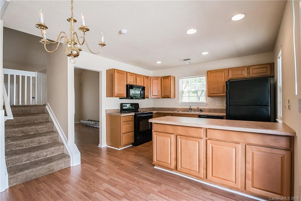 11228 Grass Field Road Charlotte, NC 28213 - Photo 12 of 26 a kitchen with stainless steel appliances granite countertop a refrigerator a oven a sink dishwasher and white cabinets with wooden floor