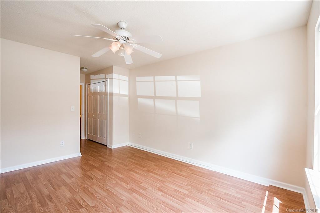 11228 Grass Field Road Charlotte, NC 28213 - Photo 15 of 26 an empty room with wooden floor fan and windows