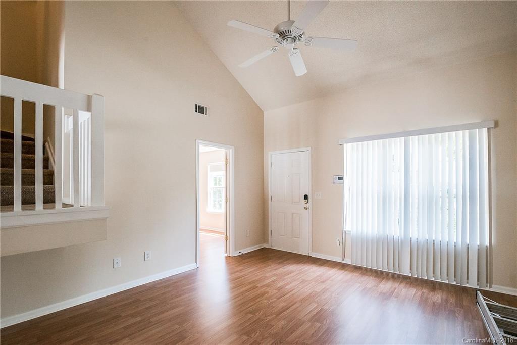 11228 Grass Field Road Charlotte, NC 28213 - Photo 6 of 26 an empty room with wooden floor fan and windows