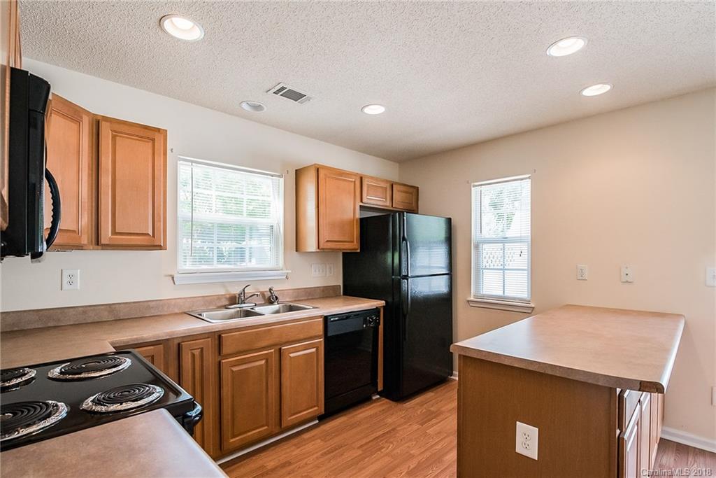11228 Grass Field Road Charlotte, NC 28213 - Photo 7 of 26 a kitchen with a refrigerator and a stove top oven