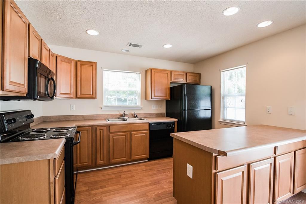 11228 Grass Field Road Charlotte, NC 28213 - Photo 8 of 26 a kitchen with stainless steel appliances granite countertop a stove refrigerator sink and microwave