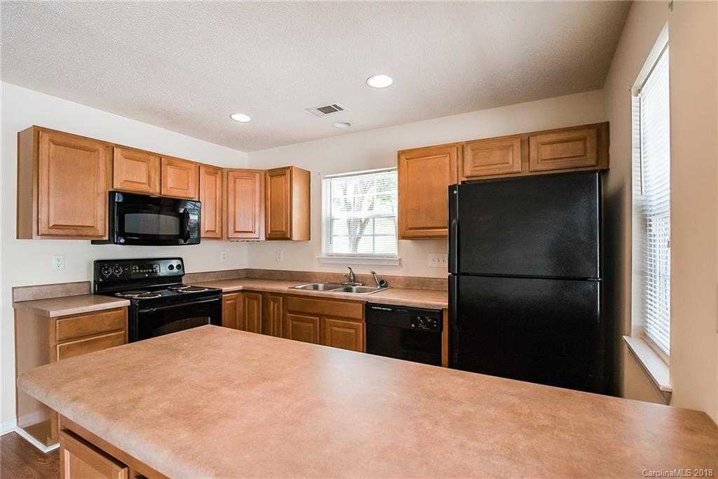 11228 Grass Field Road Charlotte, NC 28213 - Photo 9 of 26 a kitchen with stainless steel appliances granite countertop a refrigerator a stove top oven a sink and dishwasher