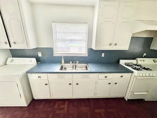 a kitchen with a sink a stove and cabinets