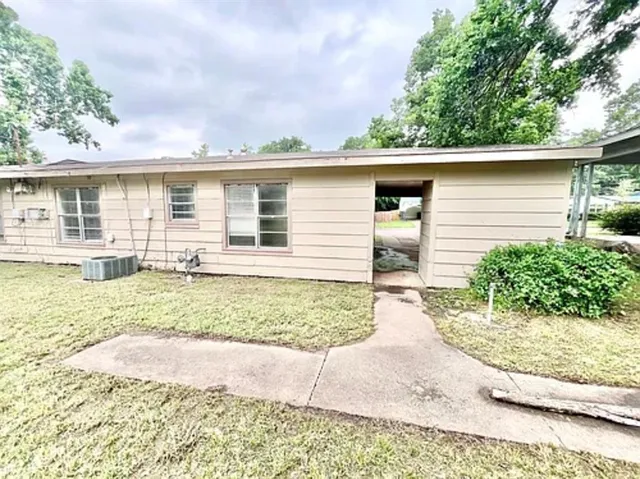 front view of house with a yard and potted plants