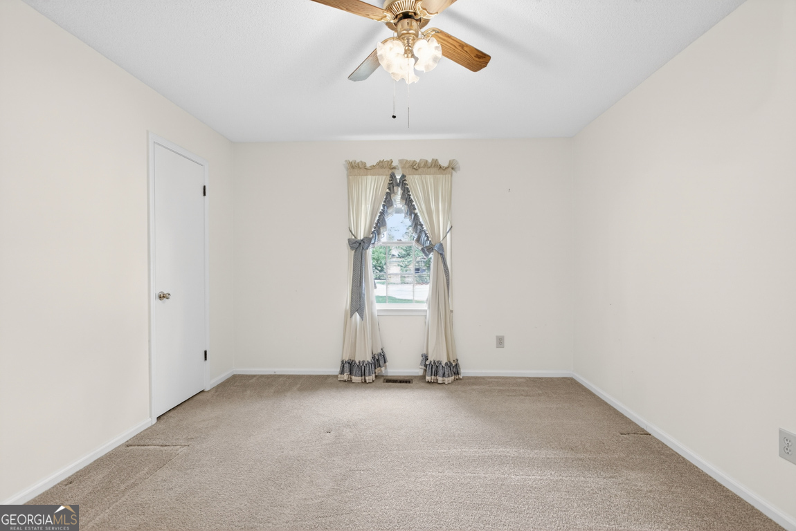 3369 Sandy Circle Macon, GA 31216 - Photo 28 of 65 an empty room with a chandelier fan and windows