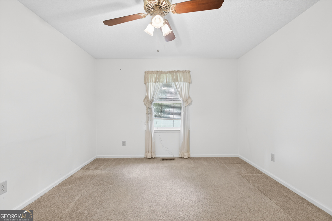 3369 Sandy Circle Macon, GA 31216 - Photo 31 of 65 an empty room with a chandelier fan and windows