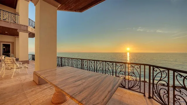 a balcony with wooden floor table and chairs