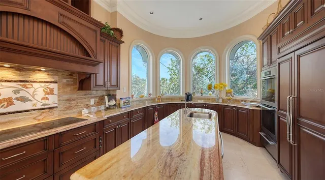 a kitchen with large windows sink and cabinets