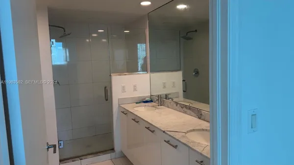 a bathroom with a granite countertop sink mirror and shower
