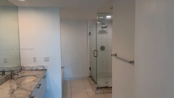 a bathroom with a granite countertop sink mirror vanity and toilet
