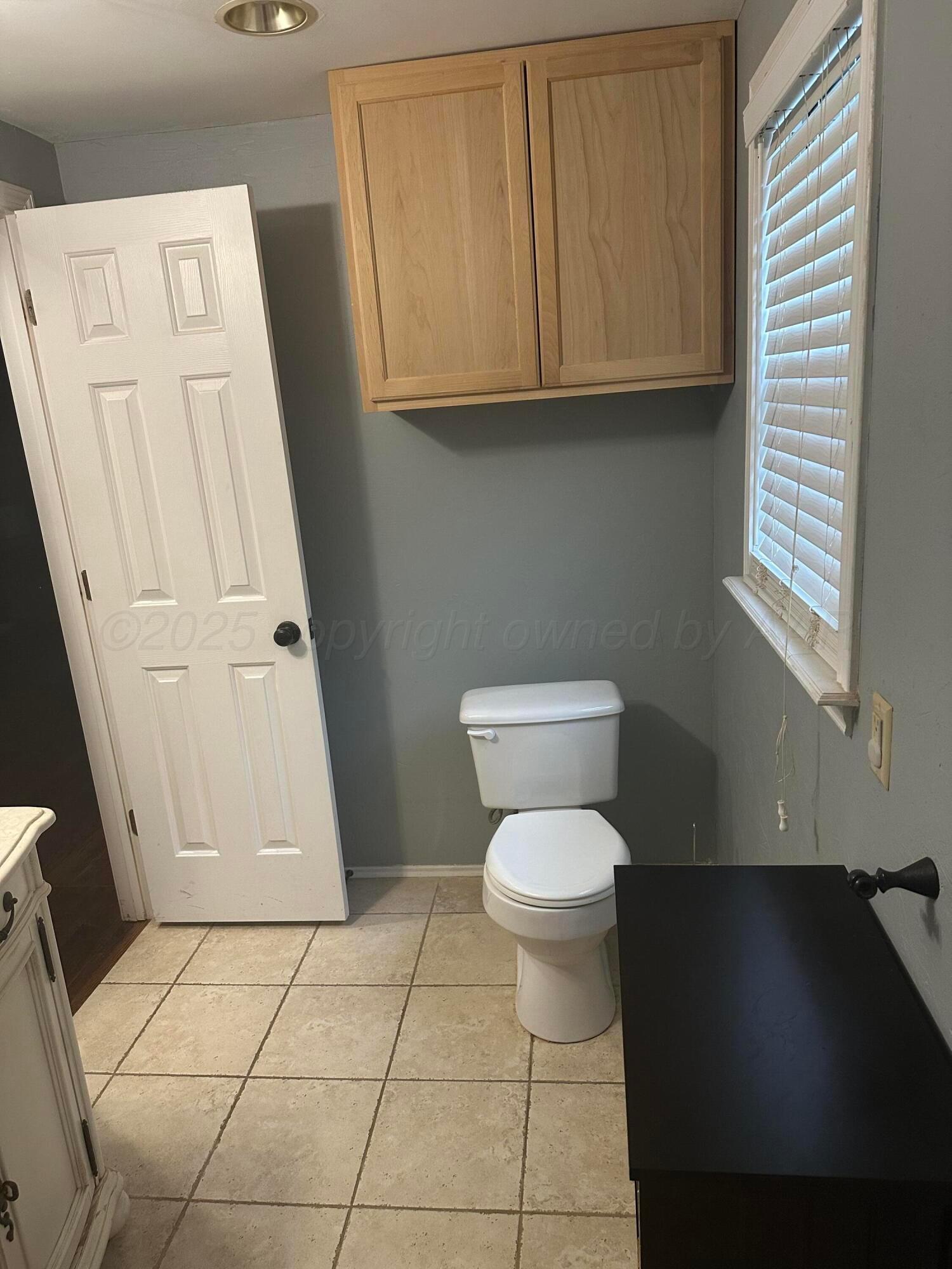 1118 Bellaire Street Amarillo, TX 79106 - Photo 27 of 36 a bathroom with a toilet a sink and a window