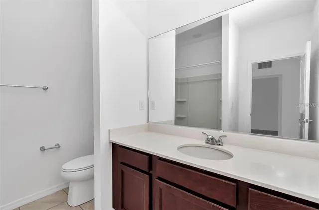a bathroom with a granite countertop sink toilet and a mirror