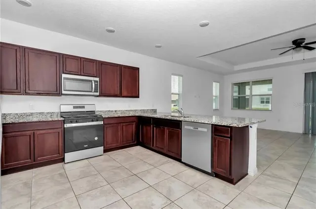 a kitchen with stainless steel appliances granite countertop a stove sink and cabinets