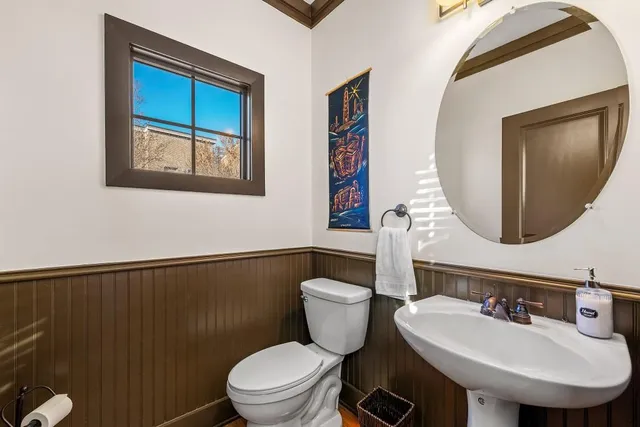 a bathroom with a toilet a sink and mirror