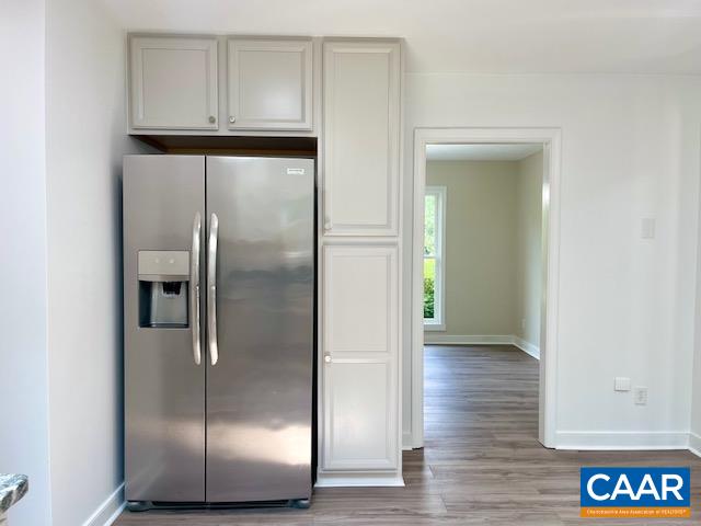 2583 Rio Mills Road Earlysville, VA 22936 - Photo 14 of 41 a view of an empty room with wooden floor kitchen view and a window