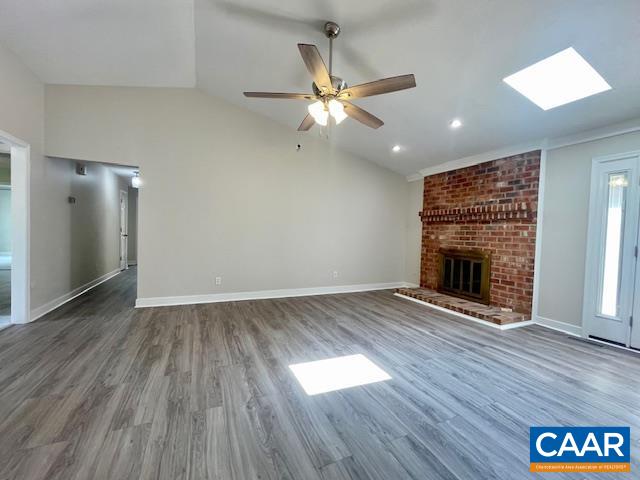 2583 Rio Mills Road Earlysville, VA 22936 - Photo 7 of 41 an empty room with wooden floor a ceiling fan a fireplace and windows