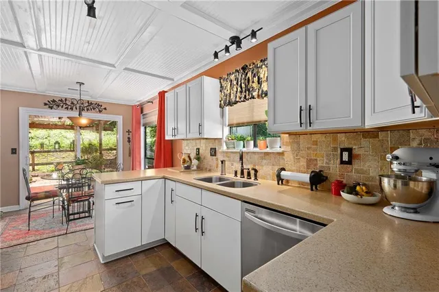 a kitchen with a sink appliances cabinets and a window