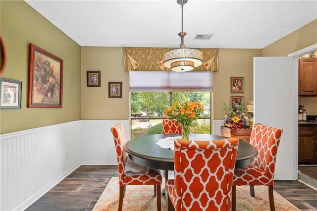 a view of a dining room with furniture a chandelier and wooden floor