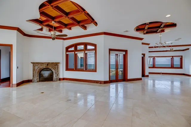 an empty room with windows and fireplace