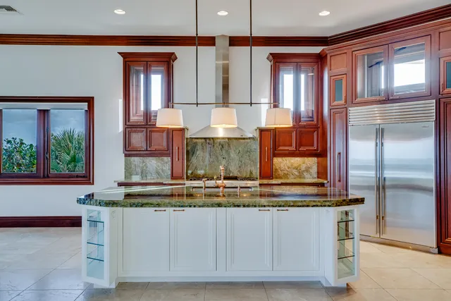 a kitchen with kitchen island granite countertop a refrigerator and window