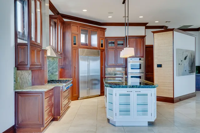a kitchen with stainless steel appliances kitchen island granite countertop a refrigerator and a stove