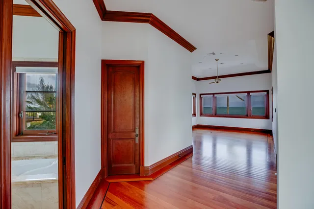 a view of an empty room with a window and wooden floor