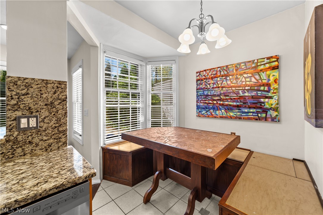 3806 Westwood Road University Heights, OH 44118 - Photo 13 of 41 Bay window dining area featuring a built-in bench, a wood-finish dining table, and tile flooring