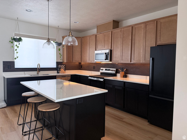 774 West 480 South American Fork, UT 84003 - Photo 10 of 76 Modern kitchen featuring a large island with a light-colored countertop, dark lower cabinetry, and complementary wood-finish upper cabinetry